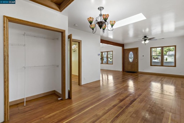 foyer featuring ceiling fan with notable chandelier and hardwood / wood-style flooring