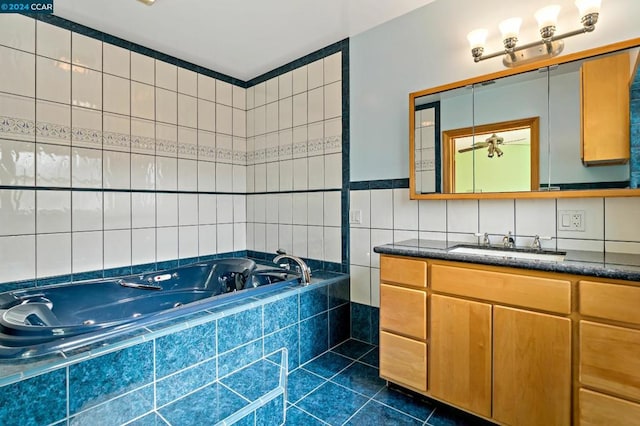 bathroom featuring tile patterned flooring, vanity, and tiled tub