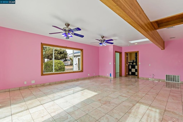 spare room with beam ceiling and ceiling fan