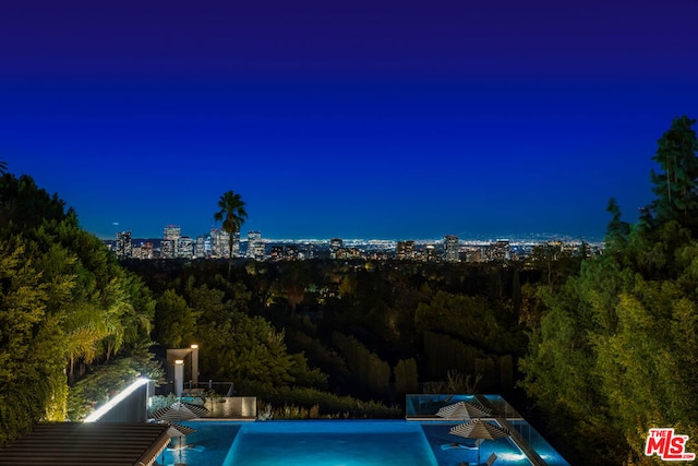 view of pool at twilight