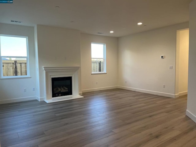 unfurnished living room with plenty of natural light and dark wood-type flooring