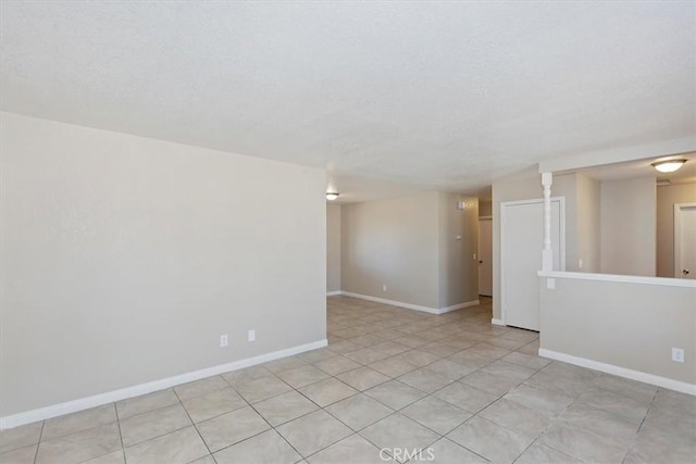 tiled empty room with a textured ceiling