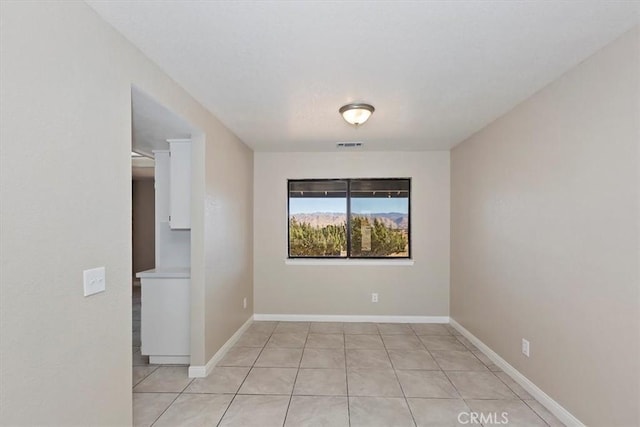 spare room featuring light tile patterned flooring