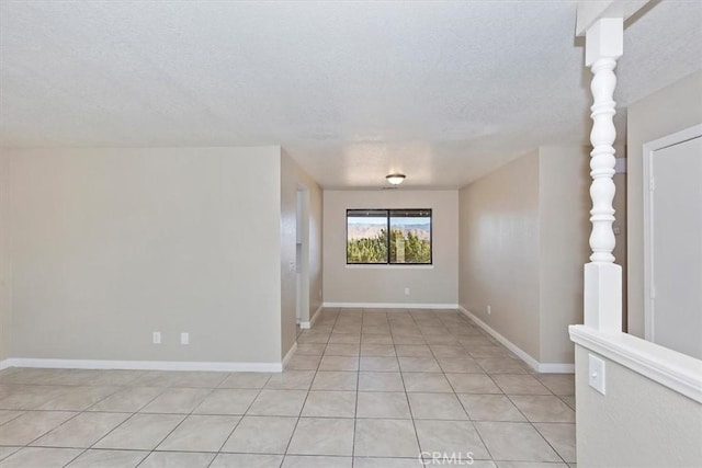 tiled empty room with a textured ceiling