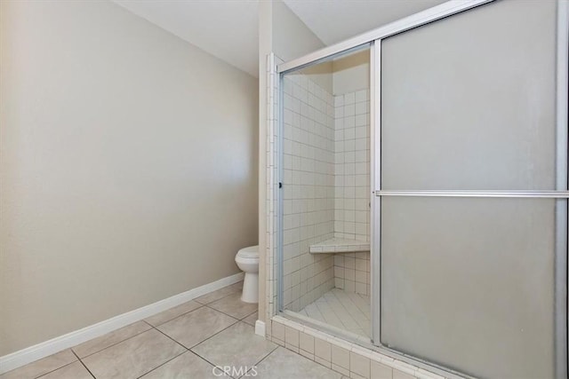 bathroom with toilet, tile patterned floors, and a shower with shower door