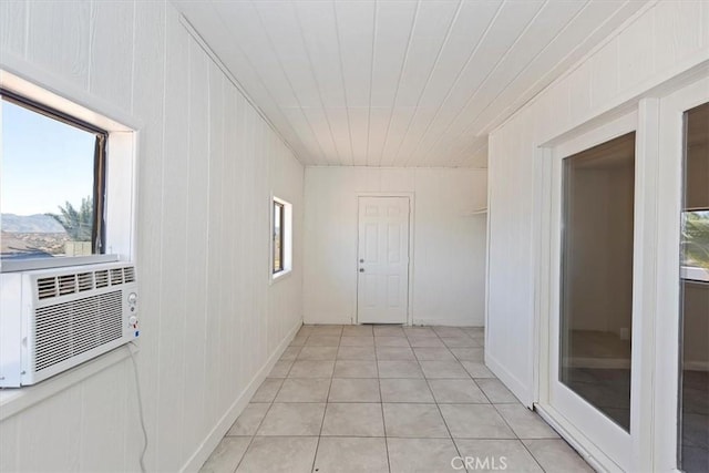 hallway with cooling unit, a mountain view, wooden walls, and light tile patterned floors