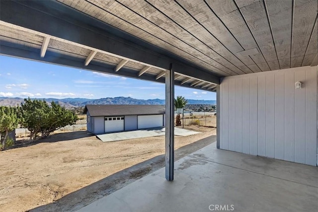 view of patio featuring a mountain view, a garage, and an outbuilding