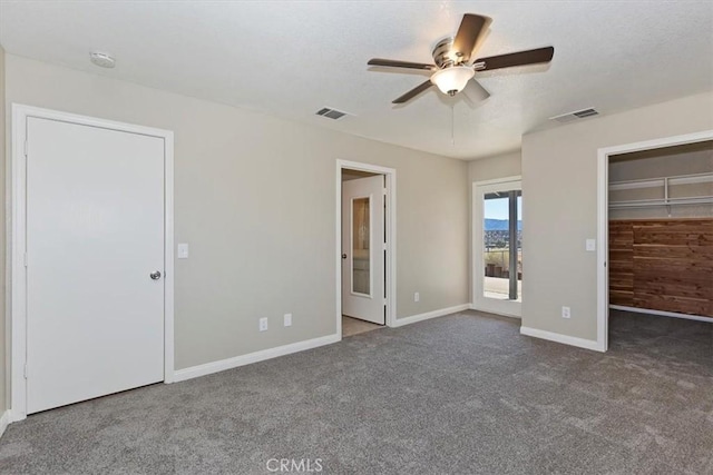 unfurnished bedroom with ceiling fan, a closet, and dark carpet