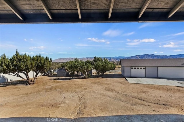 view of yard with a mountain view, an outbuilding, and a garage