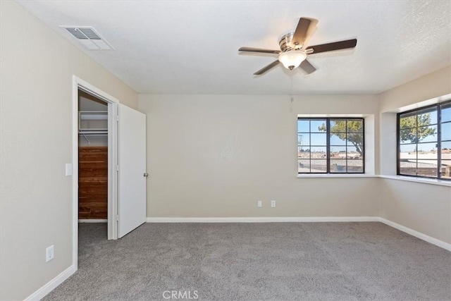 spare room with ceiling fan and light carpet