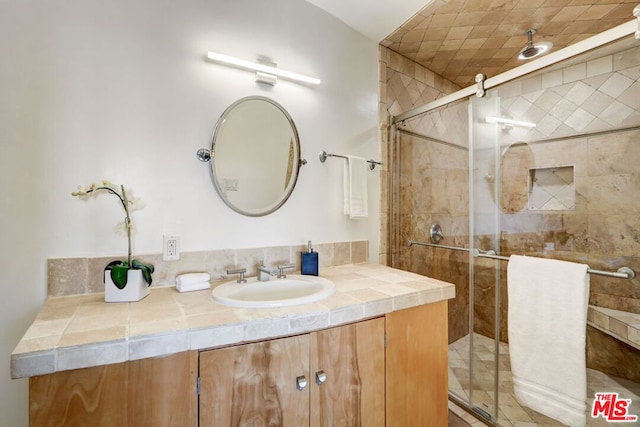 bathroom with a shower with door and vanity