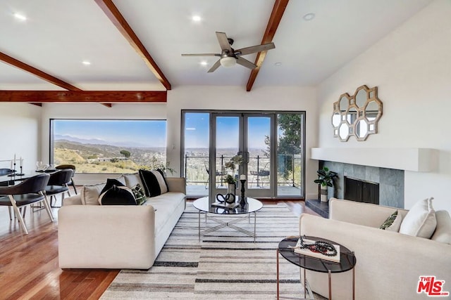 living room with plenty of natural light, beam ceiling, and wood-type flooring