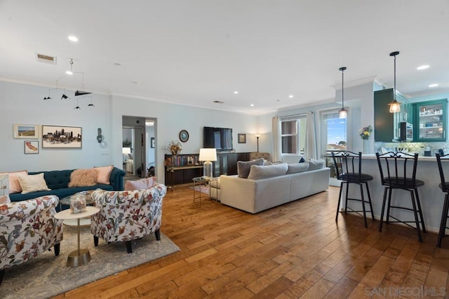 living room with hardwood / wood-style flooring and ornamental molding