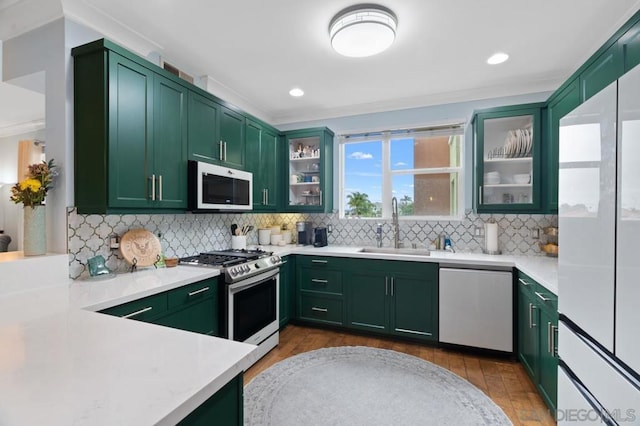 kitchen with green cabinetry, appliances with stainless steel finishes, sink, and decorative backsplash