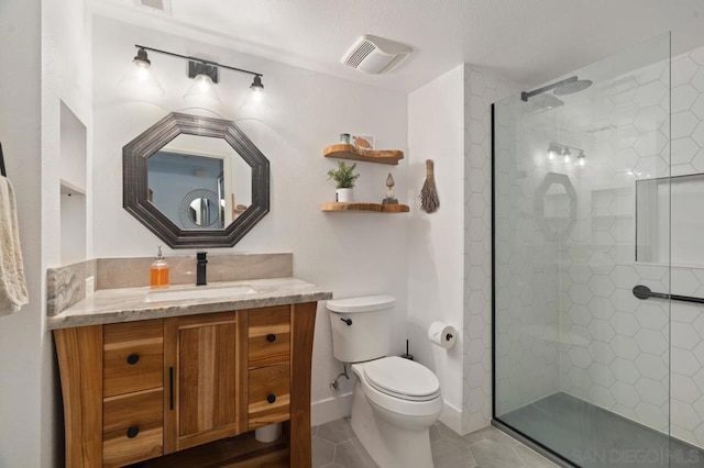 bathroom with tile patterned floors, vanity, toilet, and a tile shower