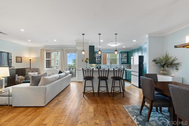 living room with crown molding and light wood-type flooring