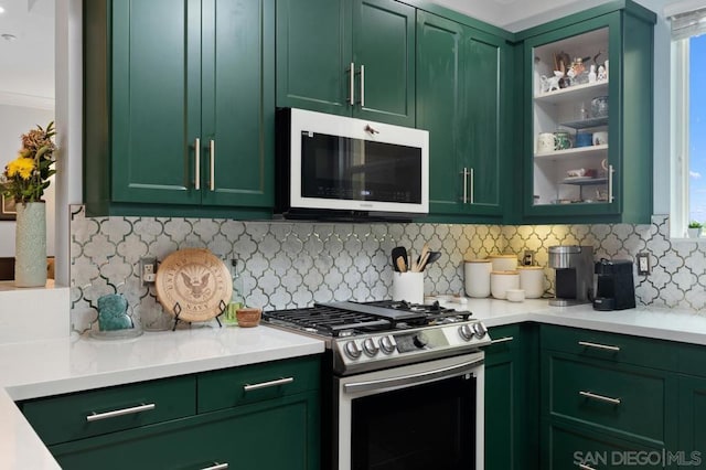 kitchen featuring backsplash, crown molding, gas stove, and green cabinets