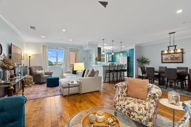 living room with crown molding and light hardwood / wood-style floors