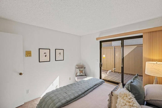 bedroom with carpet flooring, access to outside, and a textured ceiling