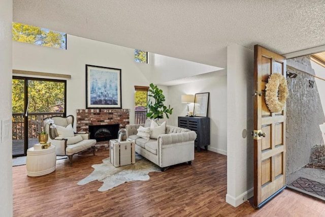 living room with a brick fireplace, hardwood / wood-style flooring, and a textured ceiling