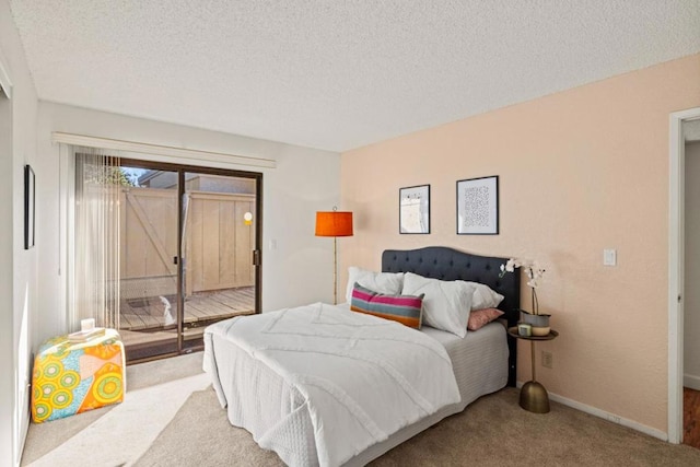 carpeted bedroom with access to exterior and a textured ceiling