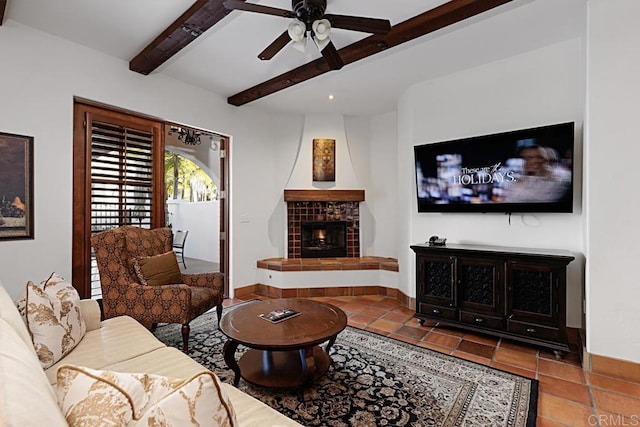 tiled living room featuring ceiling fan, a fireplace, and beamed ceiling