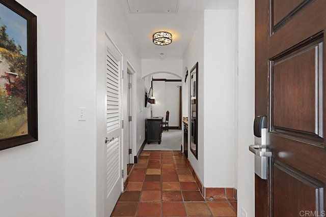 hall featuring dark tile patterned floors