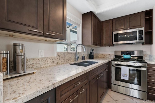 kitchen featuring light tile patterned flooring, sink, light stone counters, stainless steel appliances, and dark brown cabinets