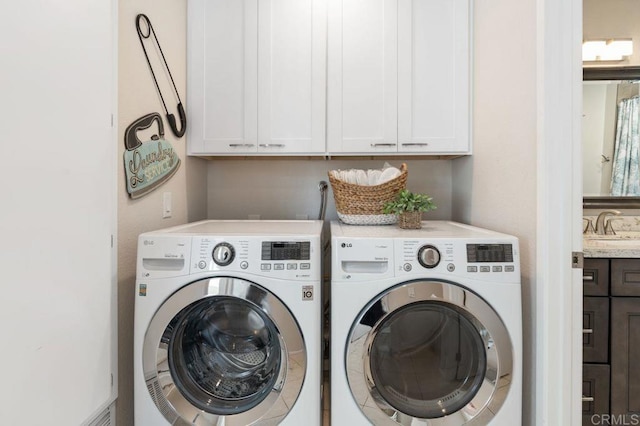 washroom featuring cabinets, sink, and washing machine and clothes dryer