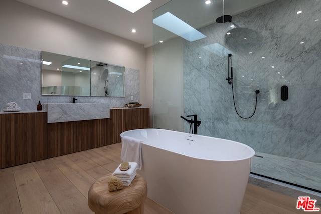 bathroom with hardwood / wood-style floors, vanity, and separate shower and tub