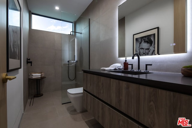 bathroom featuring vanity, a tile shower, and tile patterned flooring