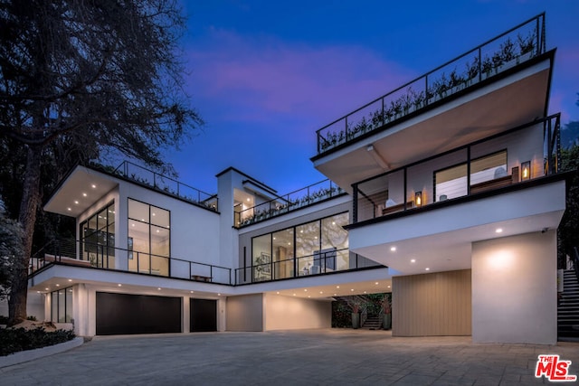 view of front of home with a garage and a balcony