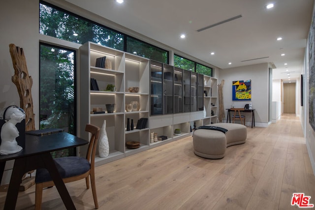 sitting room featuring expansive windows, a healthy amount of sunlight, and light hardwood / wood-style flooring