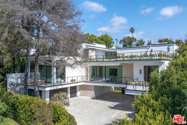 back of property featuring a garage and a balcony