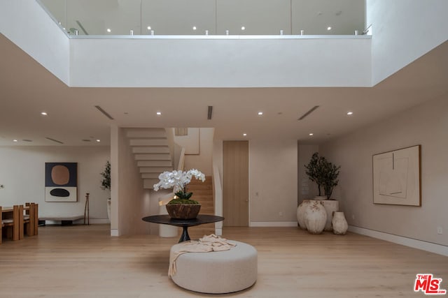 interior space with a towering ceiling and light wood-type flooring