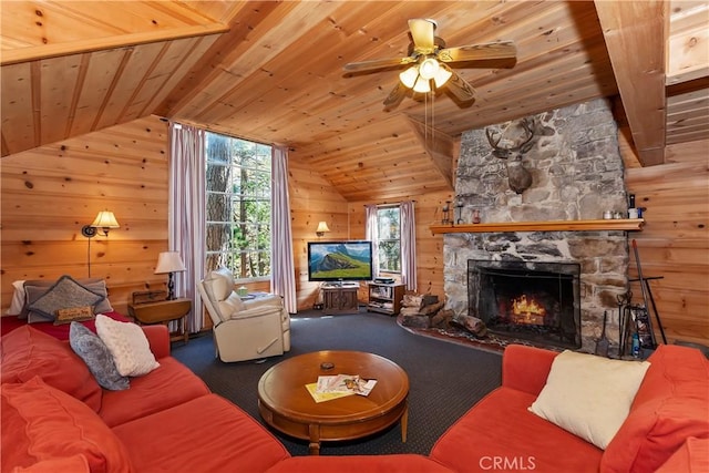 living room with vaulted ceiling, ceiling fan, wooden walls, wooden ceiling, and a stone fireplace