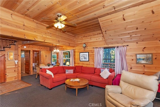 carpeted living room with ceiling fan with notable chandelier, wood walls, and wooden ceiling