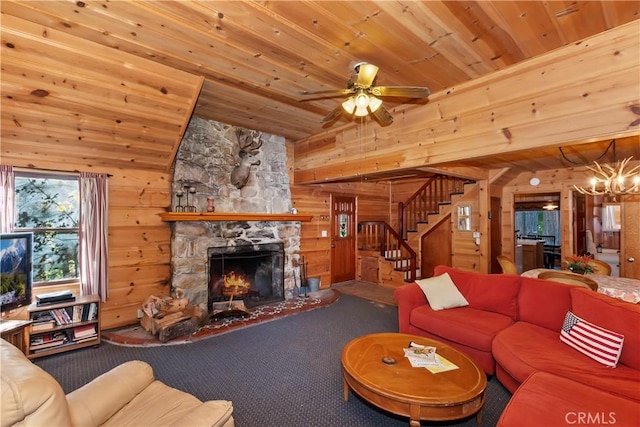 carpeted living room featuring ceiling fan with notable chandelier, wood ceiling, a fireplace, and wooden walls