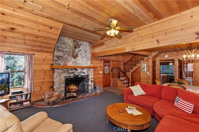 carpeted living room with a stone fireplace, ceiling fan with notable chandelier, wood ceiling, and wood walls