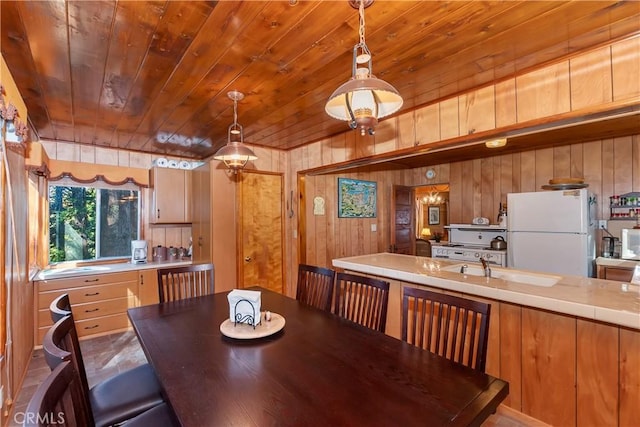 dining room with wood ceiling, sink, and wood walls