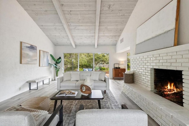 living room featuring light hardwood / wood-style floors, lofted ceiling with beams, a brick fireplace, and wooden ceiling