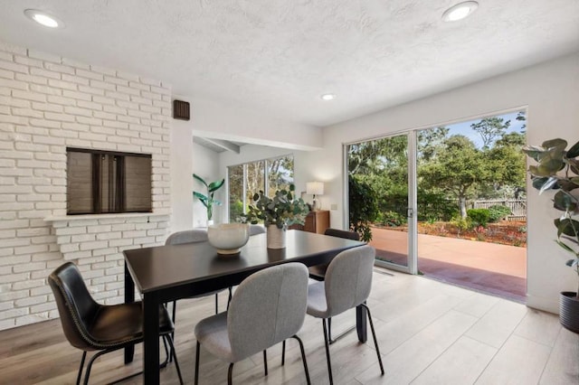 dining area with a fireplace and light hardwood / wood-style floors