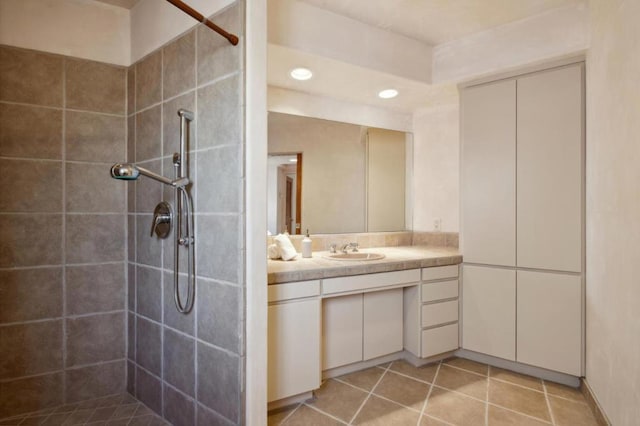 bathroom with vanity and a tile shower