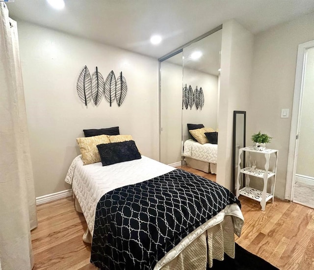 bedroom with light hardwood / wood-style flooring and a closet