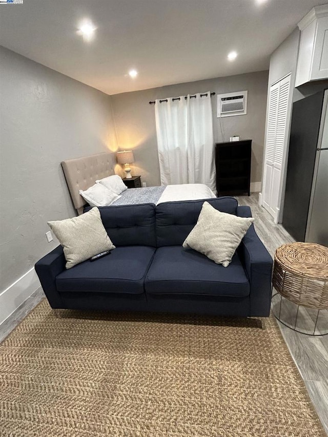 living room with a wall unit AC and hardwood / wood-style flooring