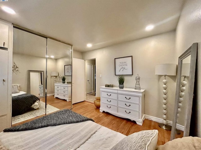 bedroom with light hardwood / wood-style flooring and a closet