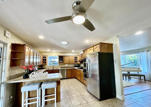 kitchen with kitchen peninsula, sink, a healthy amount of sunlight, and appliances with stainless steel finishes