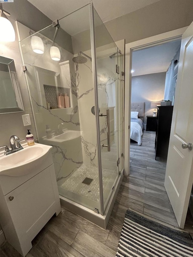 bathroom featuring hardwood / wood-style flooring, vanity, and a shower with door