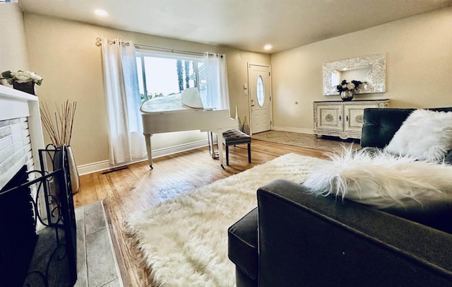 living room with light hardwood / wood-style flooring and a brick fireplace