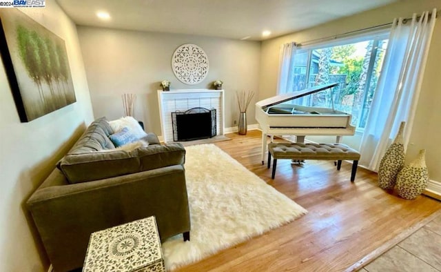 sitting room with wood-type flooring and a brick fireplace